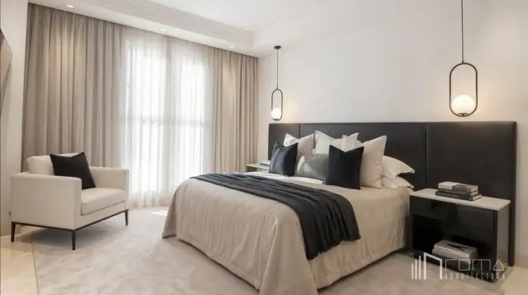 Houses 16 Finished master bedroom with white walls, marble flooring, a large black headboard, modern black nightstands, a reading armchair, and oval pendant lights after marbella property reforms by roma arquitectura studio, luxury marbella architects.