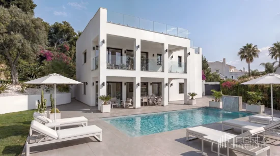 Modern white villa facade, landscaped garden, and private swimming pool with sun loungers, masterfully delivered by roma arquitectura studio, luxury puerto banus architects and interior designers for turnkey renovations
